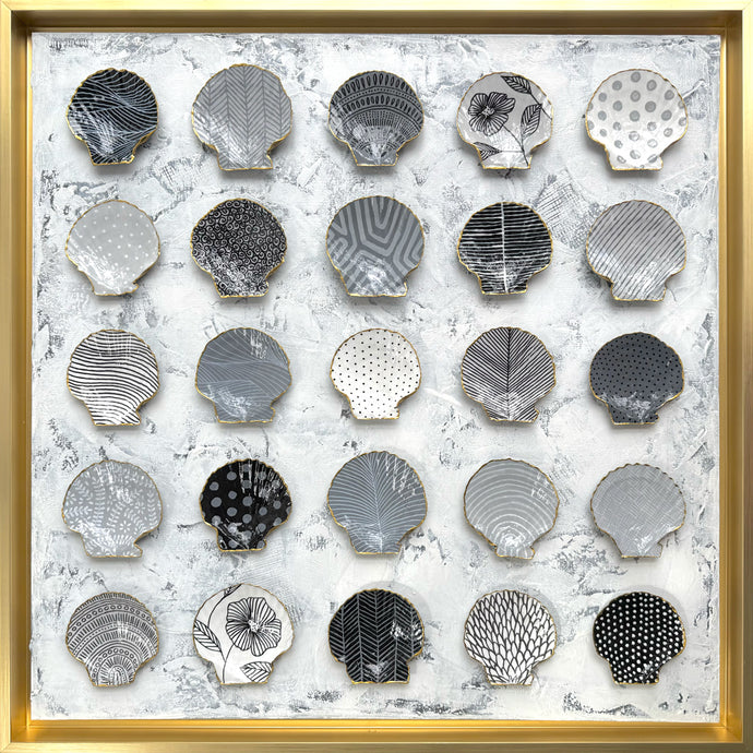 Decorative wall art with shell-shaped plates in a gold frame. ©DoraKnuteson
